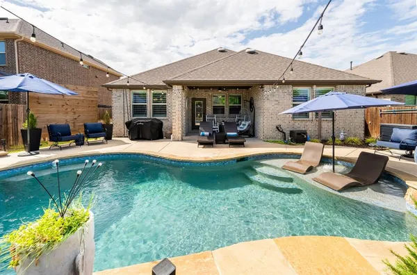 a view of a house with swimming pool and sitting area