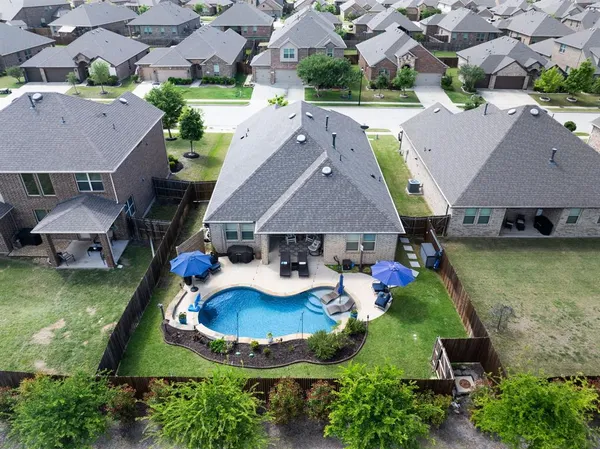 an aerial view of a house with swimming pool garden and patio