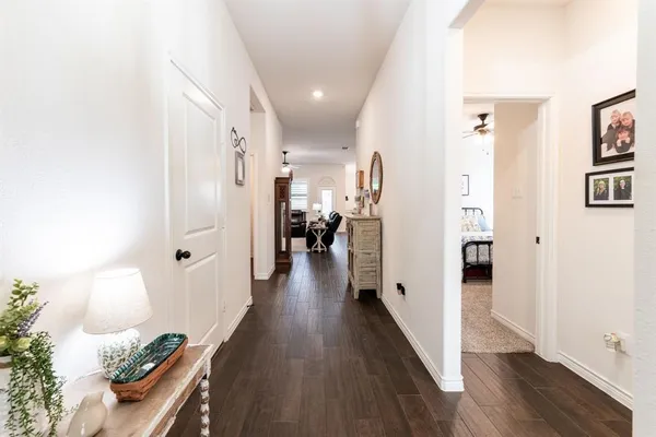 a view of a hallway with wooden floor and furniture