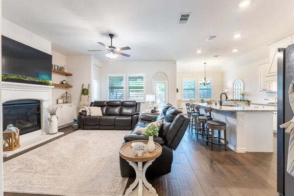 a living room with furniture a flat screen tv and a fireplace
