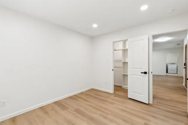 a view of a room with wooden floor and white walls
