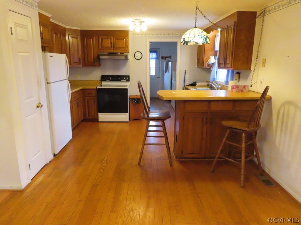 2964 West Creek Road Crewe, VA 23930 - Photo 7 of 46 a kitchen with kitchen island a stove a refrigerator and a dining table with wooden floor