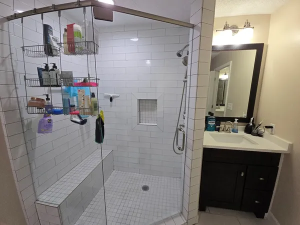 a bathroom with a sink vanity and shower
