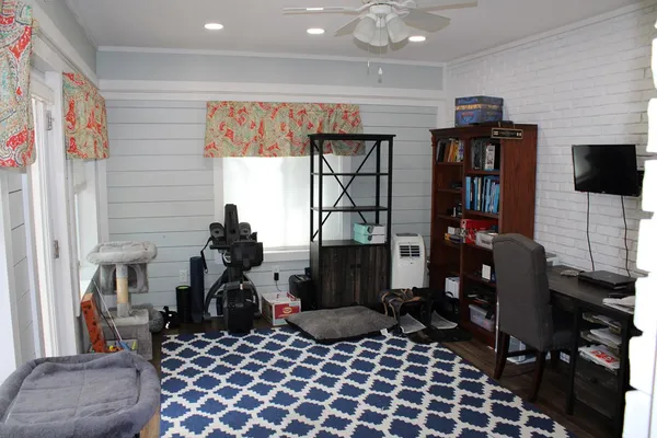 a living room with furniture a flat screen tv and a window