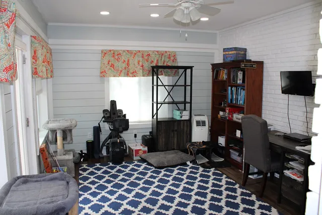 a living room with furniture a flat screen tv and a window