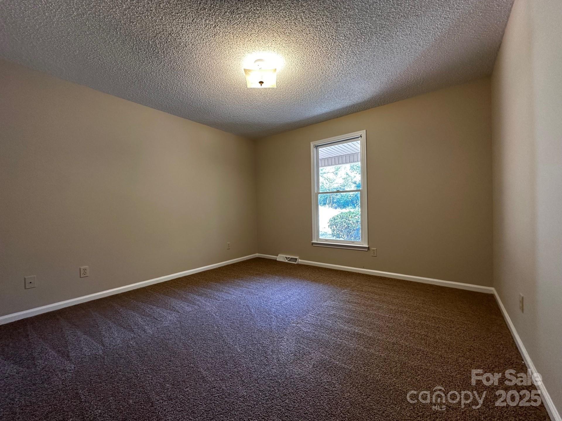 1080 Gin Road Rockwell, NC 28138 - Photo 22 of 34 an empty room with wooden floor and windows