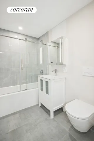 a bathroom with a white tub shower vanity and a sink
