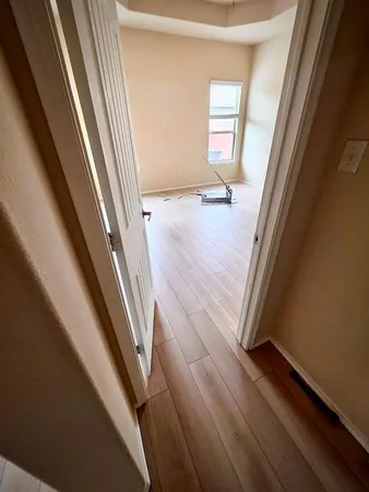 a view of a hallway with wooden floor and stairs