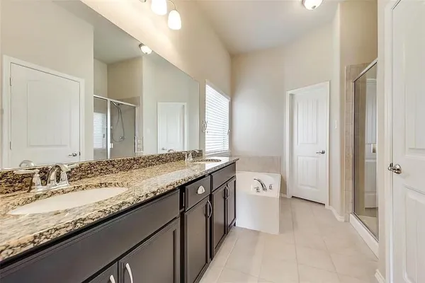 a spacious bathroom with a granite countertop double vanity sink and a mirror
