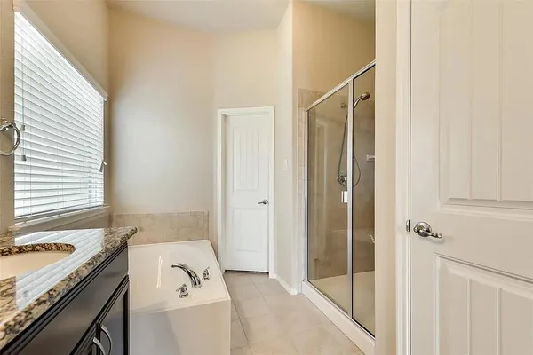 a bathroom with a granite countertop sink a mirror and a bathtub