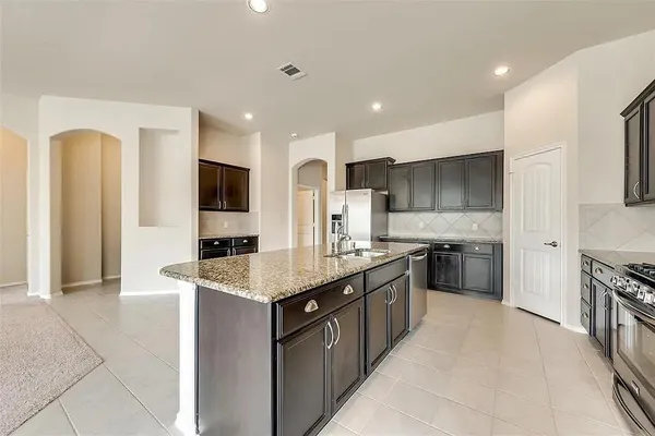 a large kitchen with stainless steel appliances granite countertop a large counter top and a stove top oven