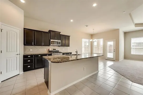 a large kitchen with stainless steel appliances granite countertop a stove and a sink