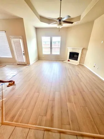 a view of a livingroom with wooden floor and a ceiling fan