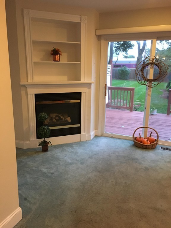 120 Maple Street, Unit 120 Needham, MA 02492 - Photo 3 of 14 an empty room with windows fireplace and fan