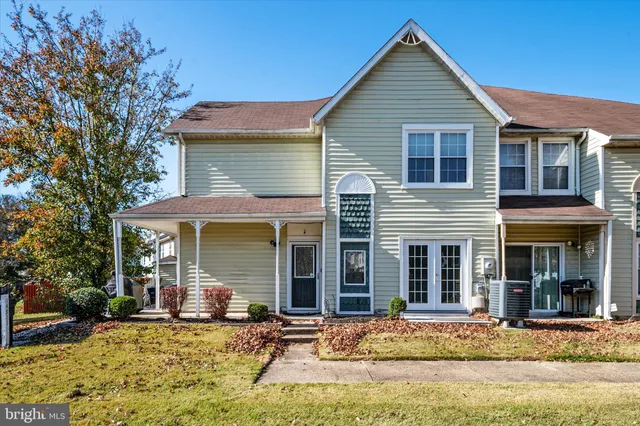 a front view of a house with yard patio and glass windows