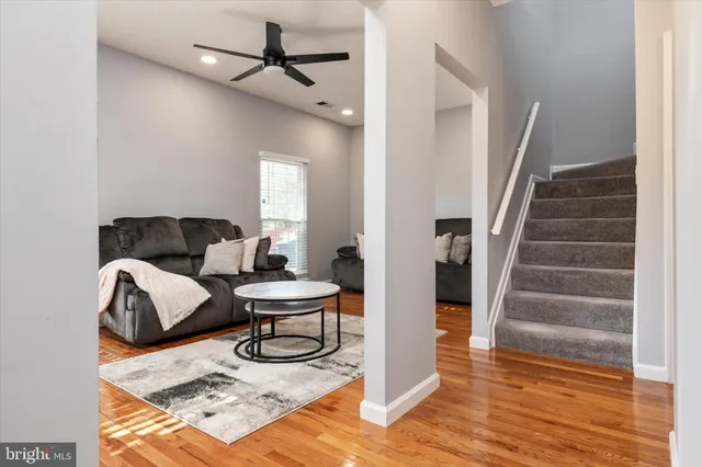 a living room with furniture and a wooden floor