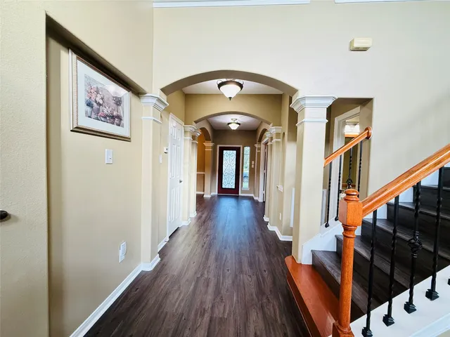 a view of a hallway with wooden floor and staircase