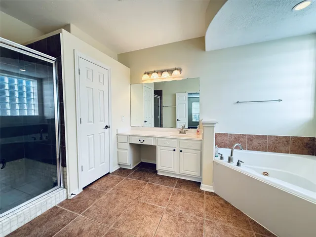 a bathroom with a tub a sink and a mirror