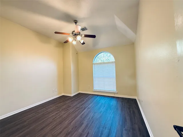 an empty room with a window and wooden floor