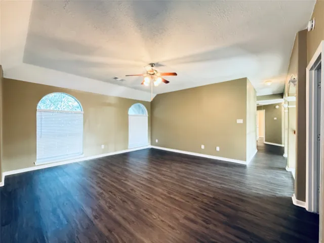 a view of an empty room with wooden floor