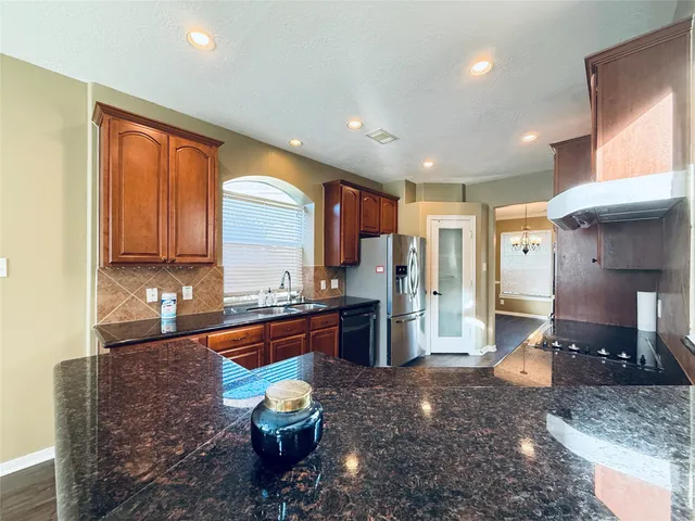a kitchen with stainless steel appliances granite countertop a sink stove and refrigerator