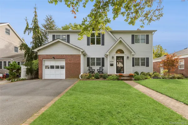 a front view of a house with a yard and garage