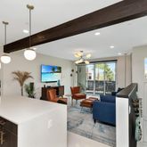 a living room with furniture a large window and a chandelier