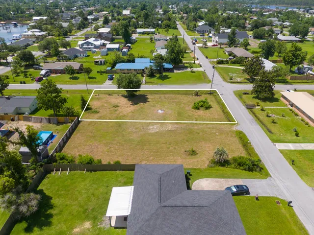 an aerial view of a tennis ground and a cars park side of the road