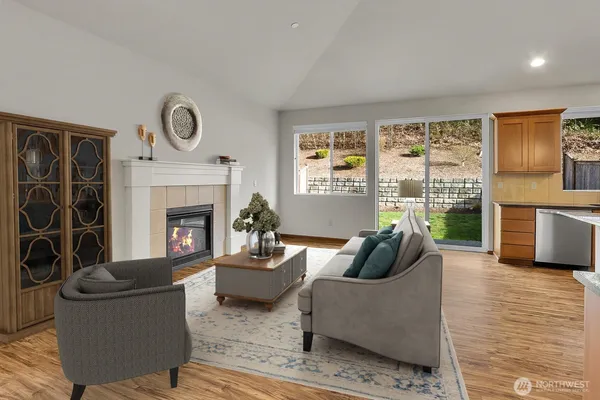 a living room with furniture a fireplace and a floor to ceiling window