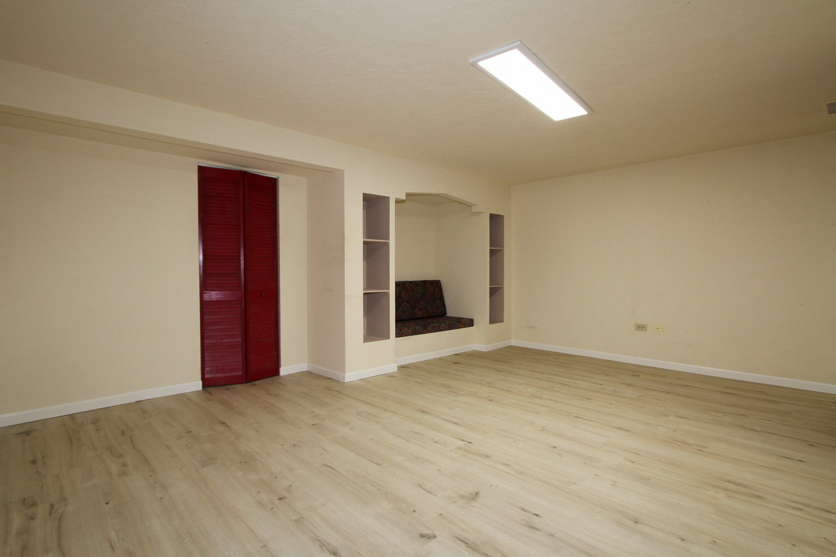 1960 Slippery Rock Road Naperville, IL 60565 - Photo 20 of 22 a view of an empty room with wooden floor and a ceiling fan