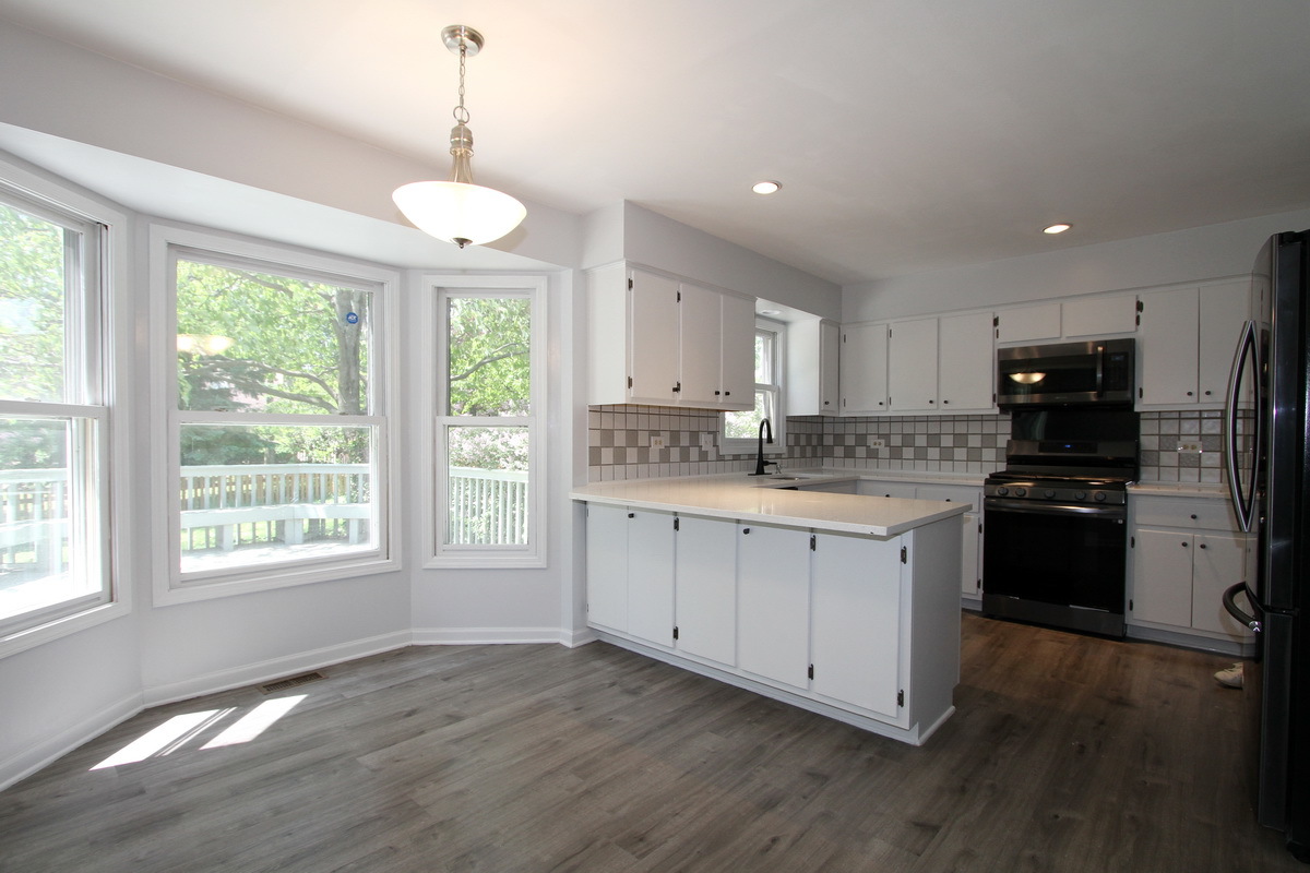 1960 Slippery Rock Road Naperville, IL 60565 - Photo 7 of 22 a kitchen with a refrigerator a center island cabinets and a large window