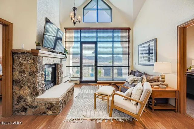 a living room with furniture large window and wooden floor