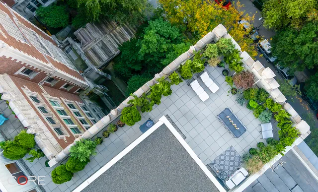 an aerial view of multi story residential apartment building with a yard and potted plants