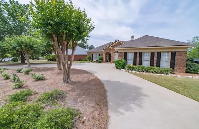 a front view of a house with a yard and trees