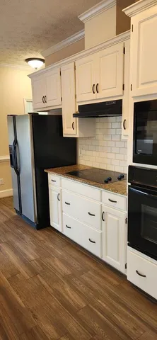a kitchen with stainless steel appliances a cabinets and wooden floor