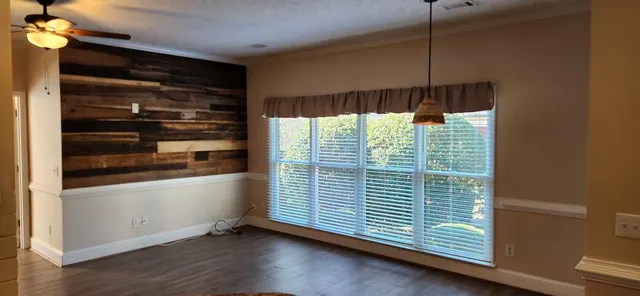a view of a room with window wooden floor and brick walls
