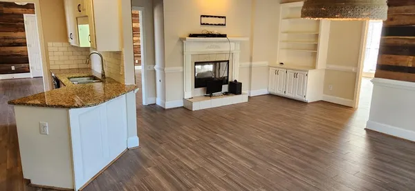 a view of a livingroom with wooden floor and fireplace