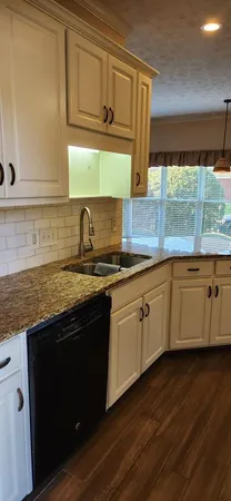 a kitchen with granite countertop cabinets stainless steel appliances and a sink