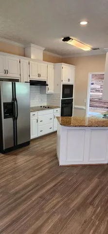 a kitchen with stainless steel appliances granite countertop a stove a sink and a refrigerator