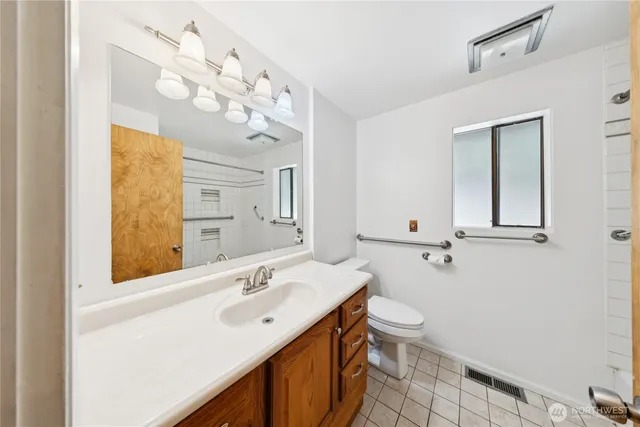 a bathroom with a sink vanity mirror and toilet