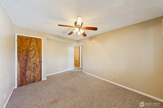 a view of a big room with windows and chandelier fan