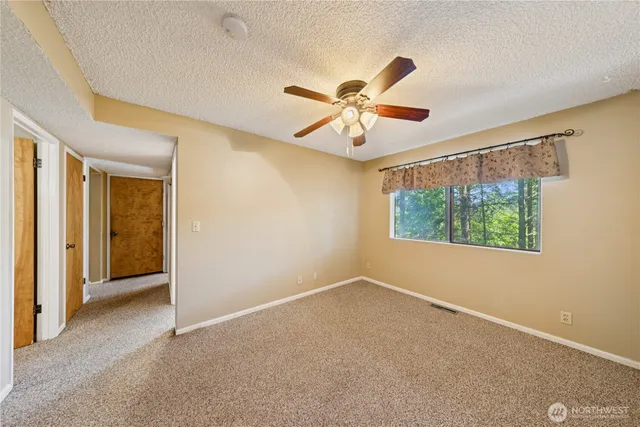 a view of a big room with windows and chandelier fan