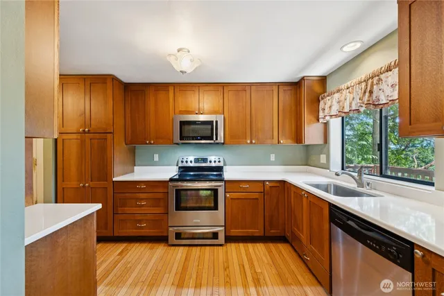 a kitchen with stainless steel appliances a stove sink and microwave