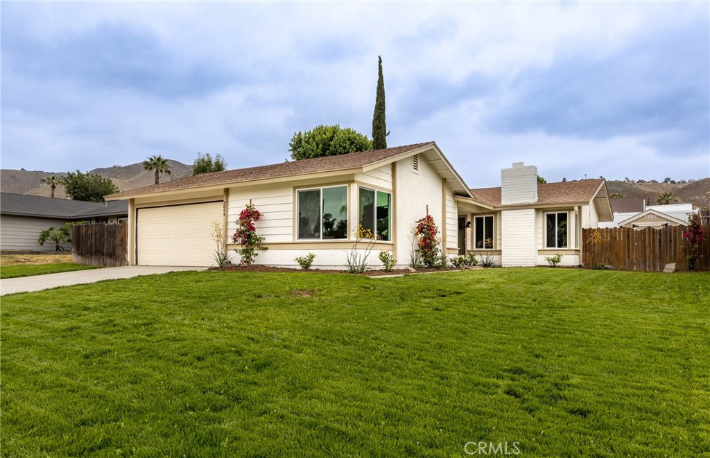 a front view of a house with a garden and yard