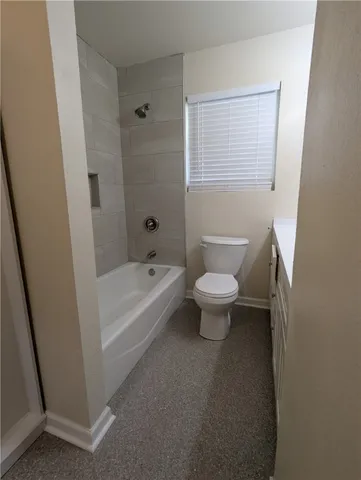 a white toilet sitting next to a bath tub