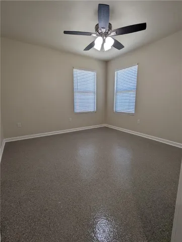 an empty room with windows and fan
