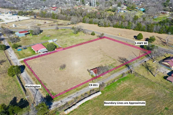 an aerial view of a tennis ground and a building in the background