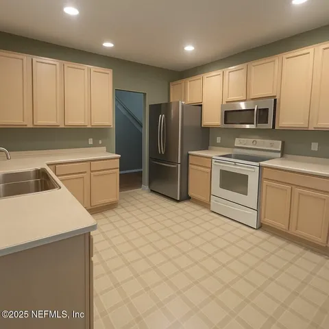 a kitchen with stainless steel appliances granite countertop a refrigerator sink and stove