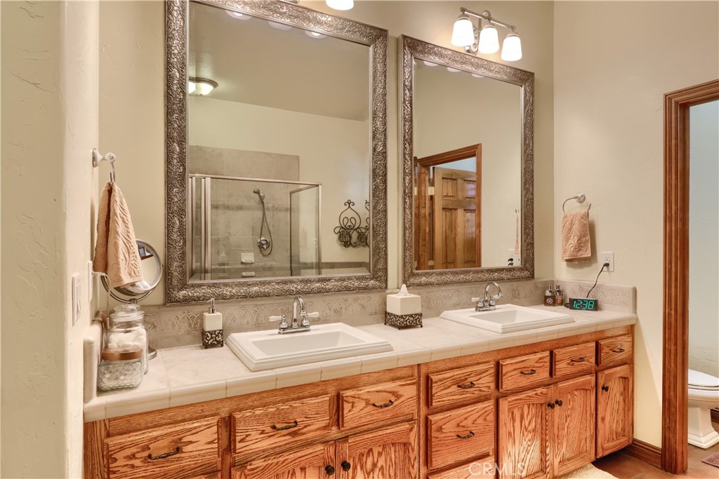 1087 Ben Hur Road Raymond, CA 93653 - Photo 27 of 75 a bathroom with double vanity sinks and a mirror