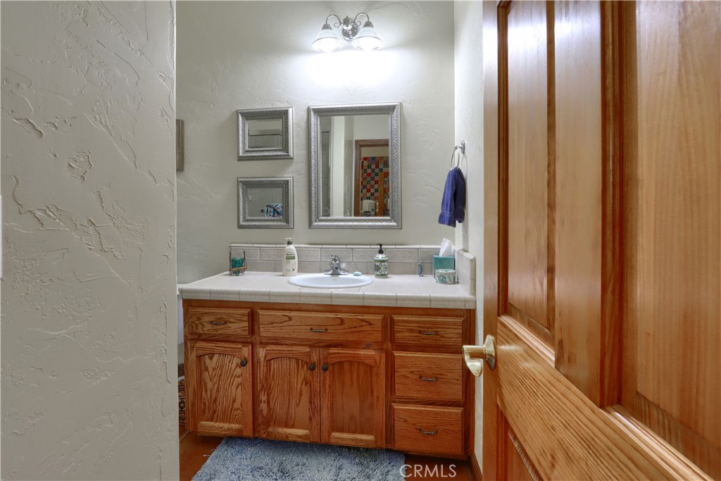 1087 Ben Hur Road Raymond, CA 93653 - Photo 37 of 75 a bathroom with a granite countertop sink and a mirror